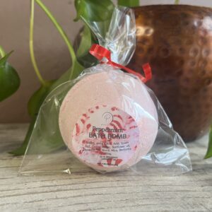 Pink peppermint bath bomb on wooden surface.