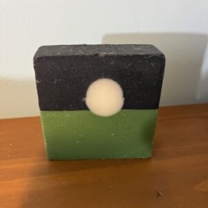 Square soap with black and green layers.